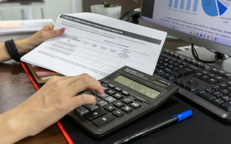 Financial documents and calculator on a desk.