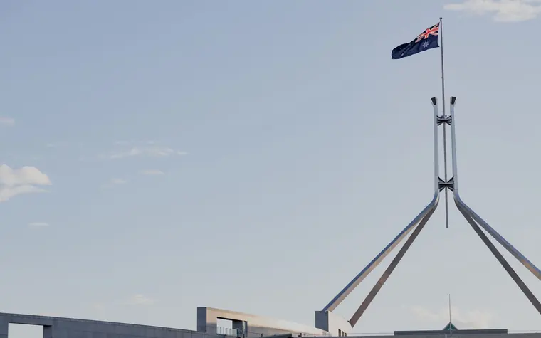 Australian Parliament House in Canberra beneath a clear blue sky.