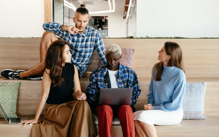 Business colleagues discussing work beside a laptop.