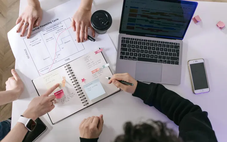 Overhead view of a team planning content around a calendar and laptop.