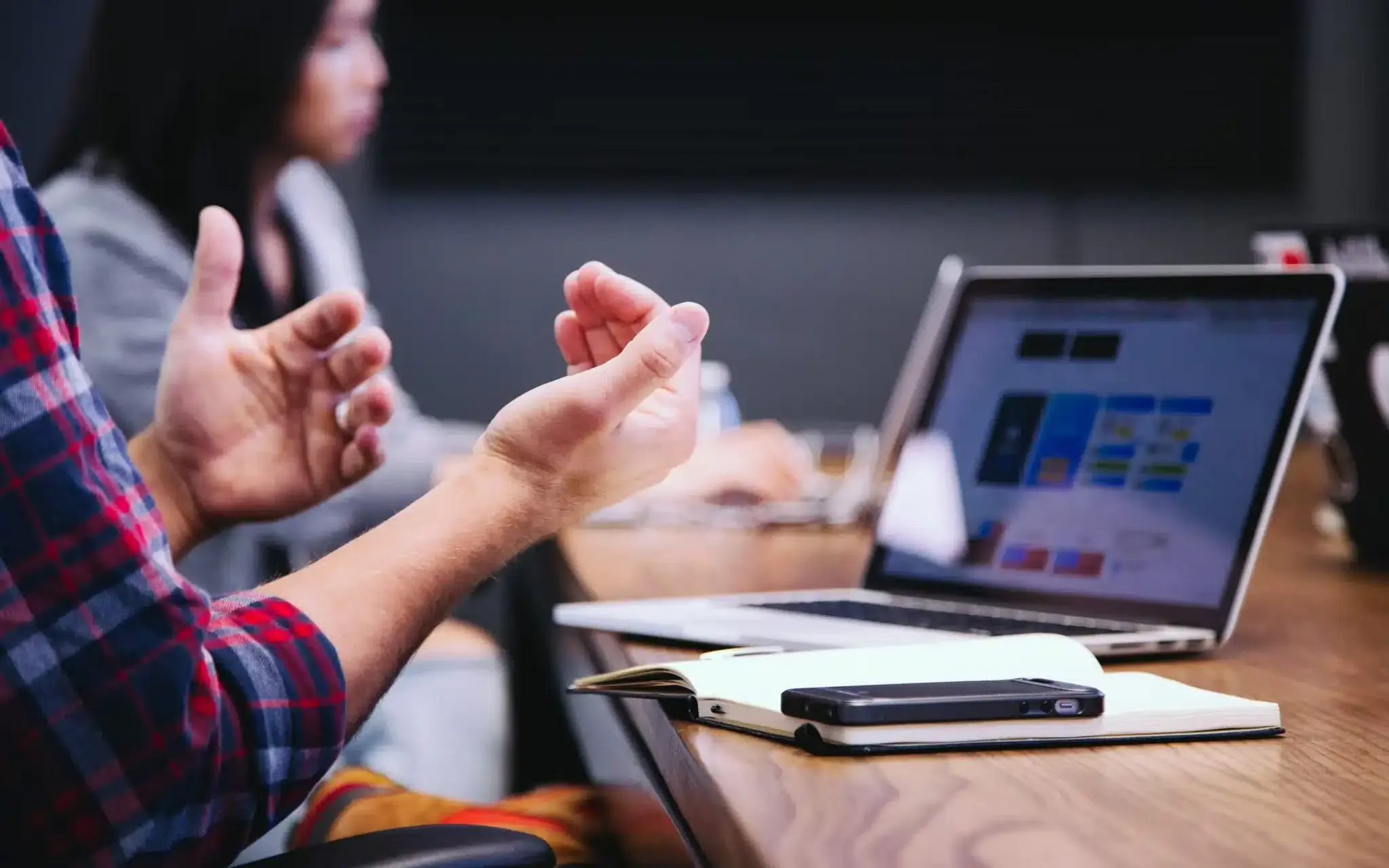 Discussion across laptops in a meeting.