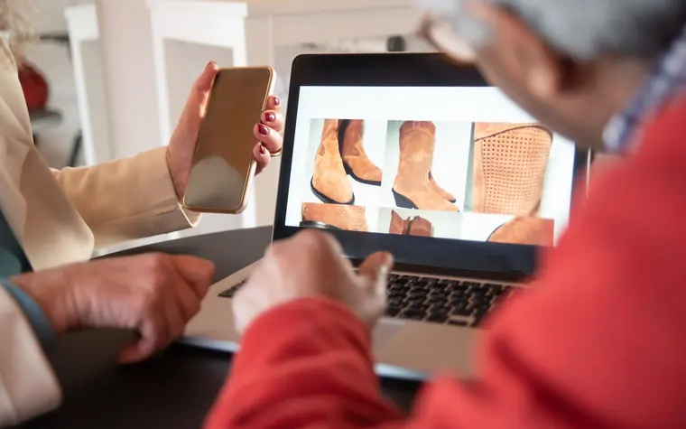 Two people browsing products in an online store on a laptop.