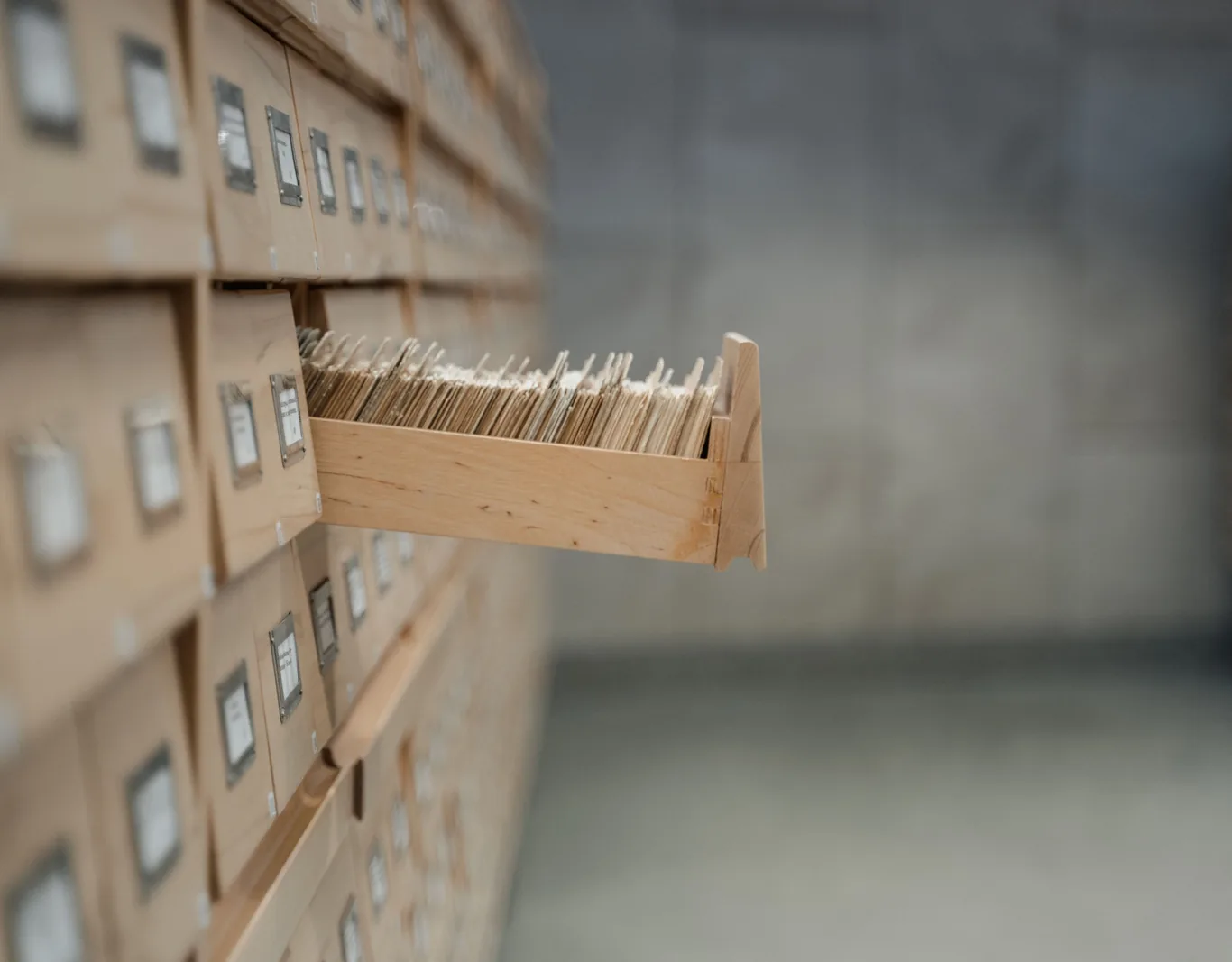 Library card catalogue with one drawer pulled open to reveal rows of index cards.