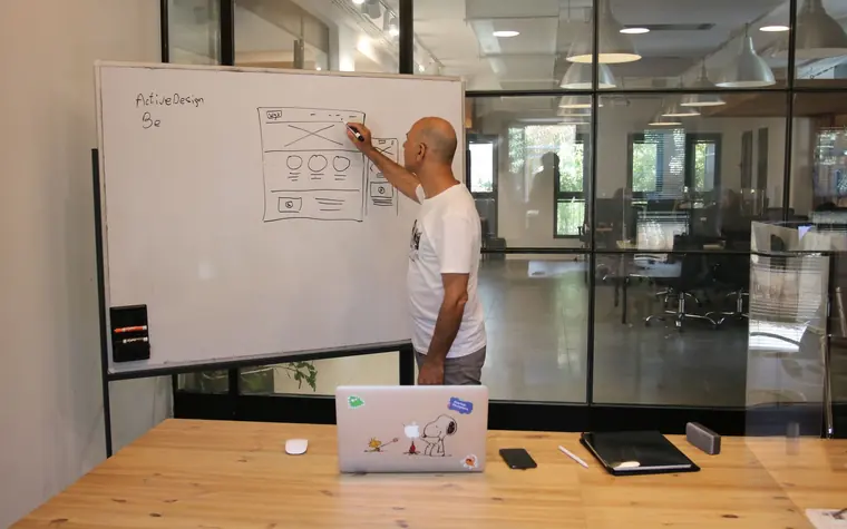 Developer sketching website architecture on a whiteboard.