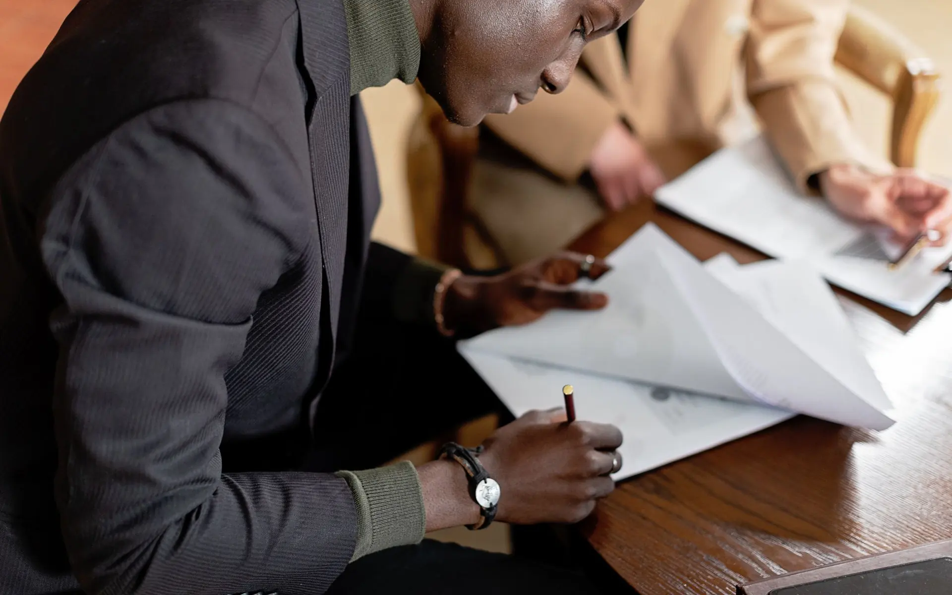 Businessman reviewing and signing a formal document.