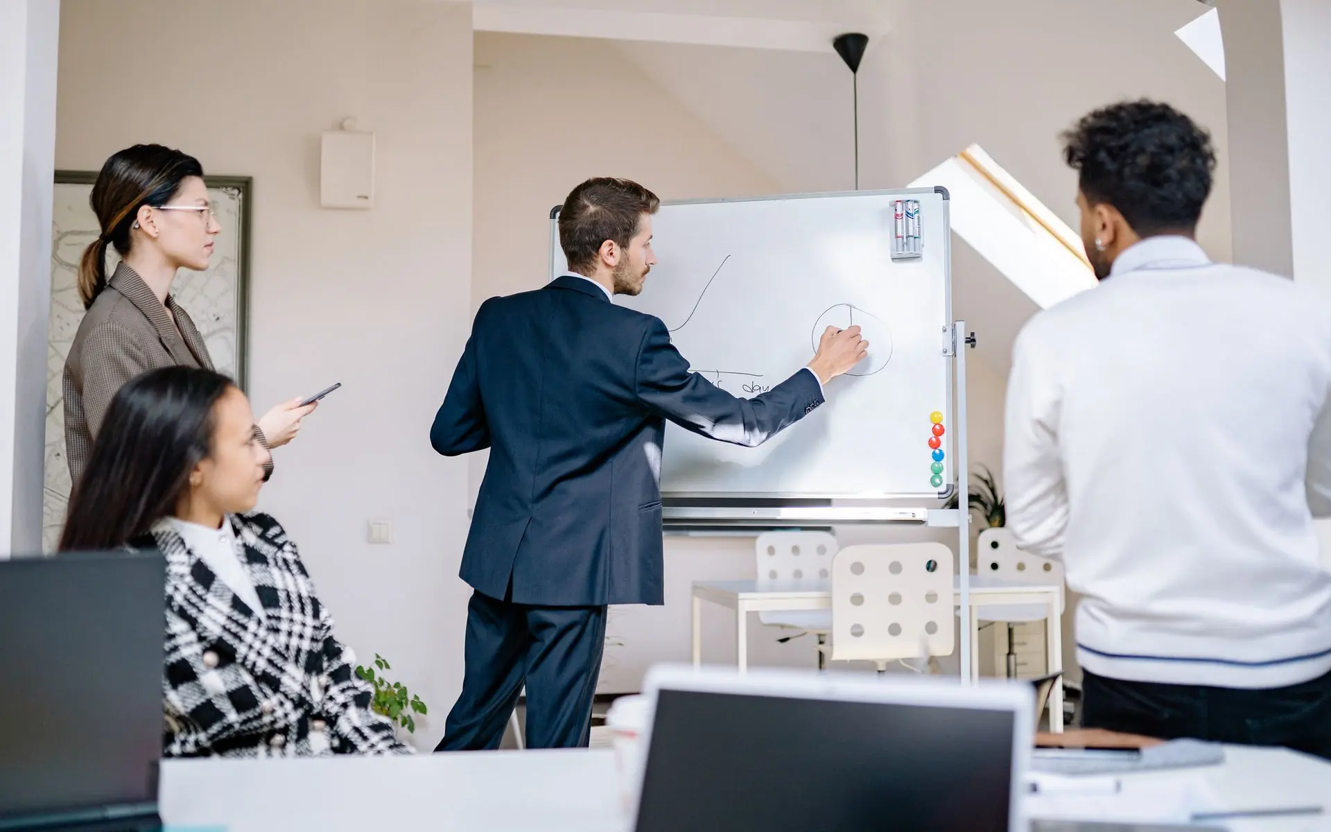 Colleagues collaborating at a whiteboard.