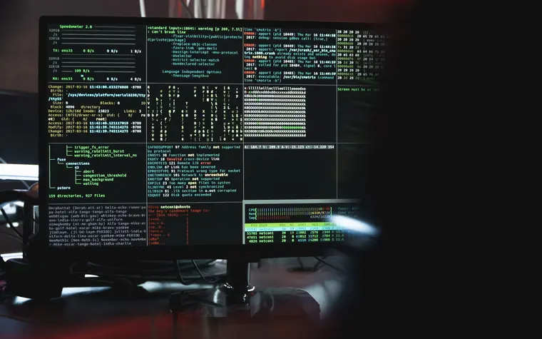 Security monitoring screens in a dark operations environment.