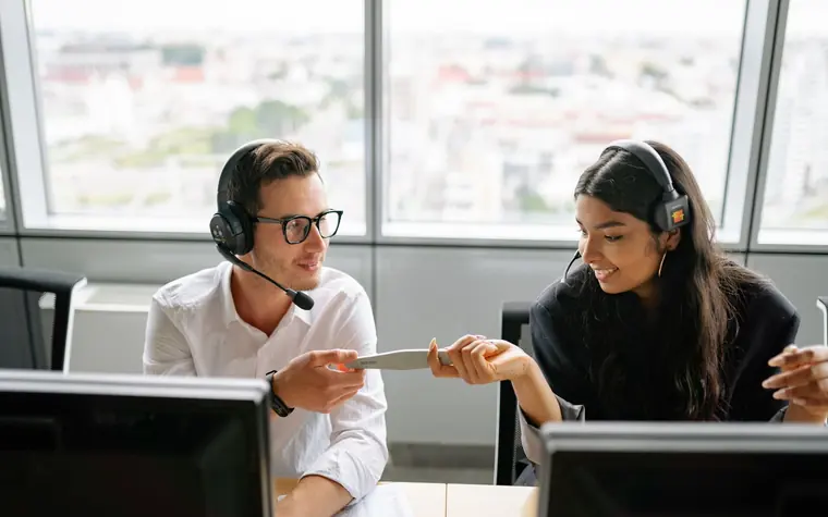 Support team members wearing headsets at their desks.