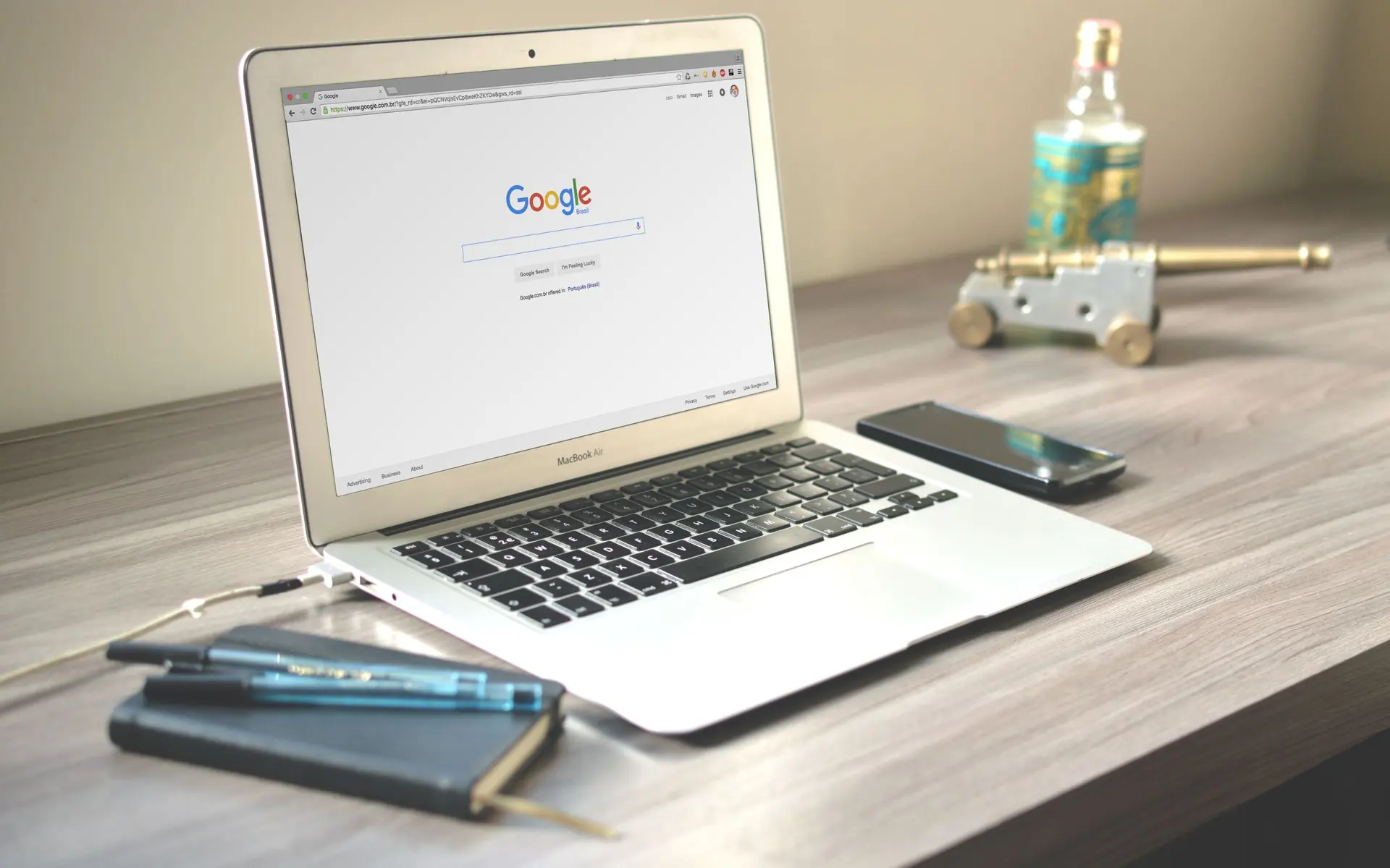 Google open on a laptop with a phone beside it.