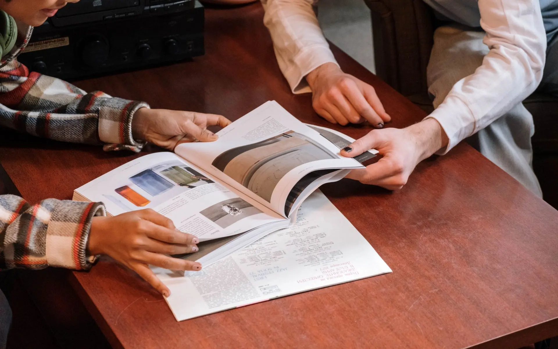 Printed editorial layouts spread across a table.