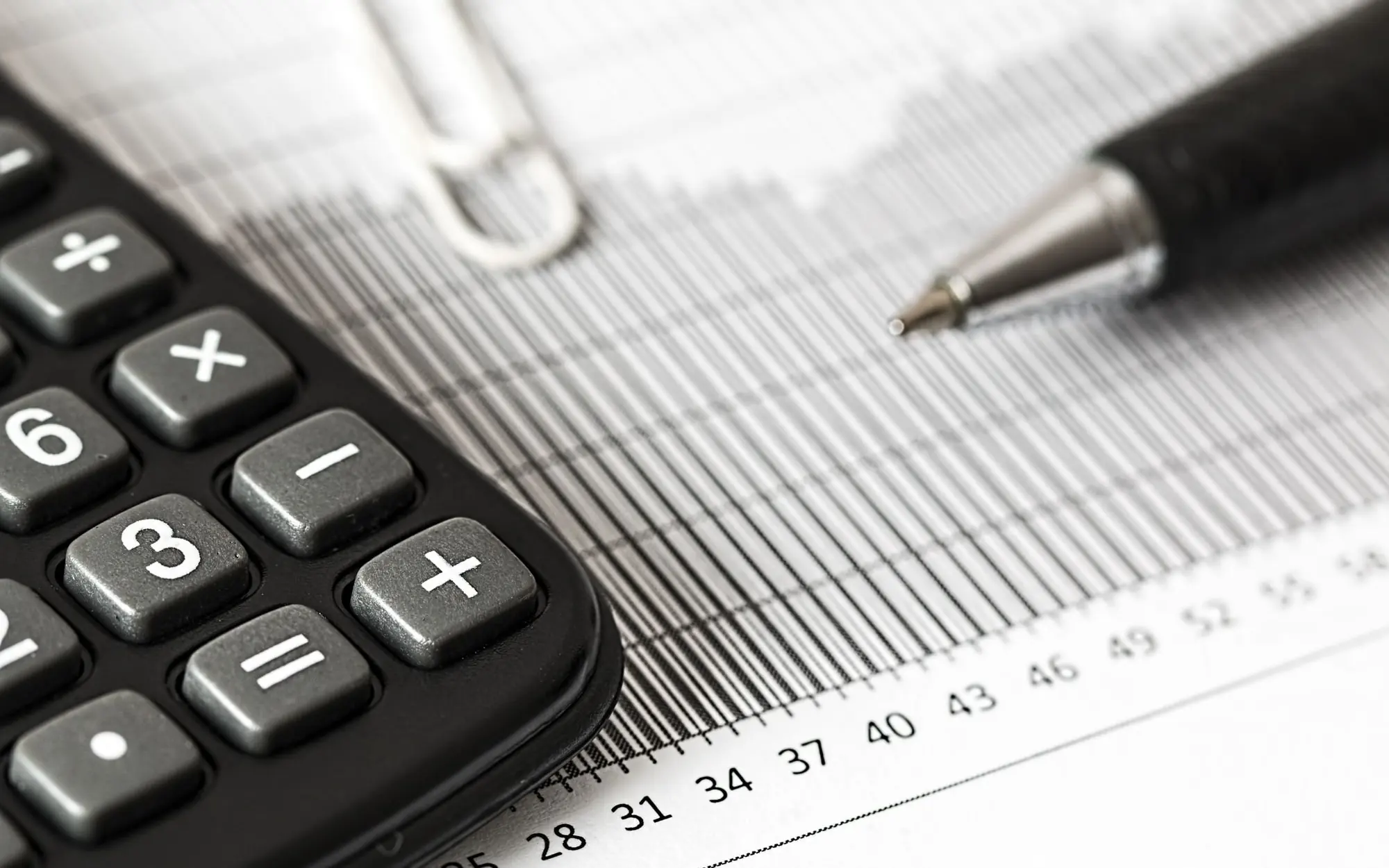 Calculator and pen on a table.