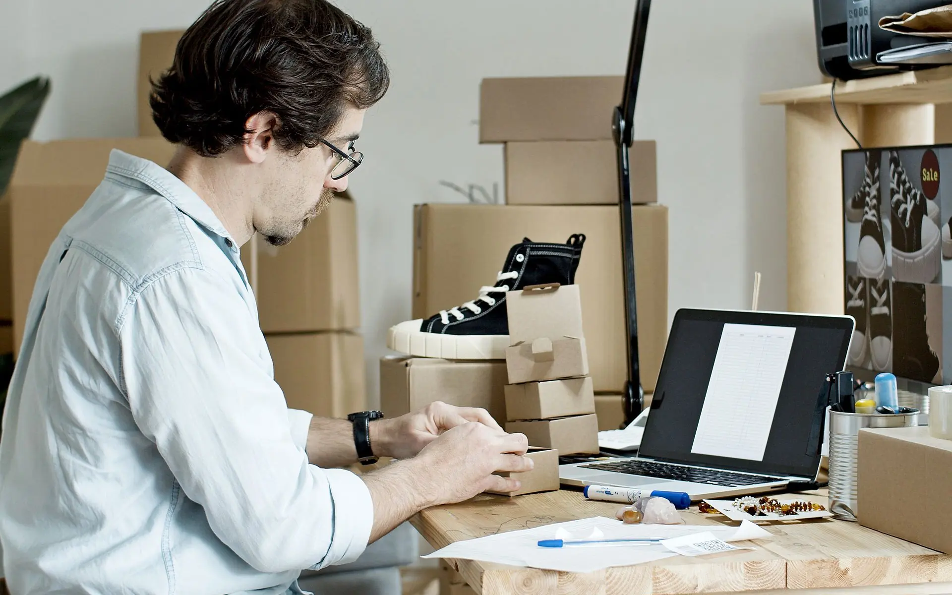 Store owner packing customer orders at a desk.