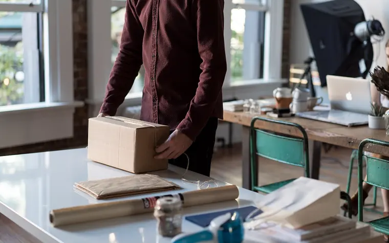 Person packing a parcel for shipping.