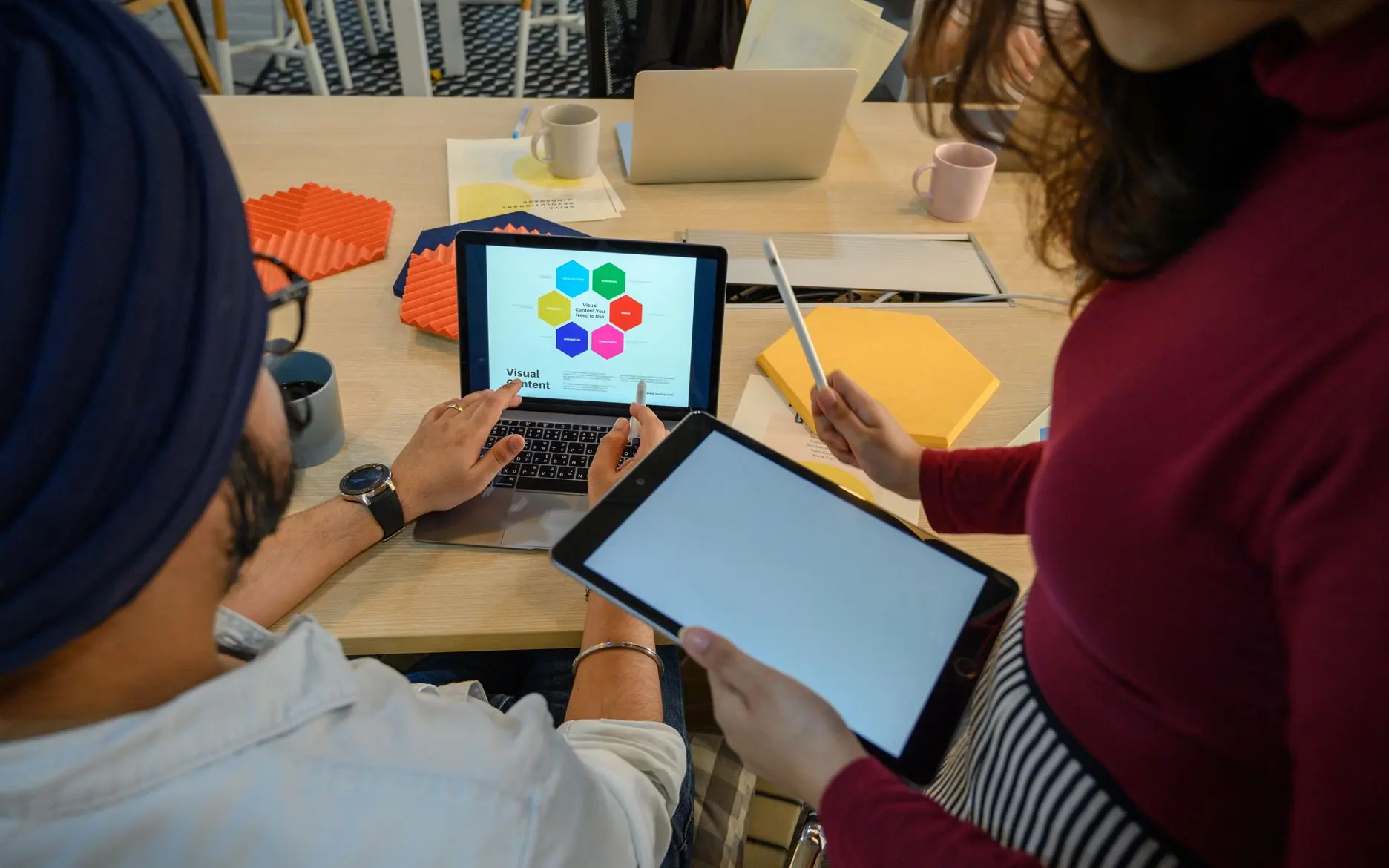 Two colleagues reviewing a screen with a stylus.