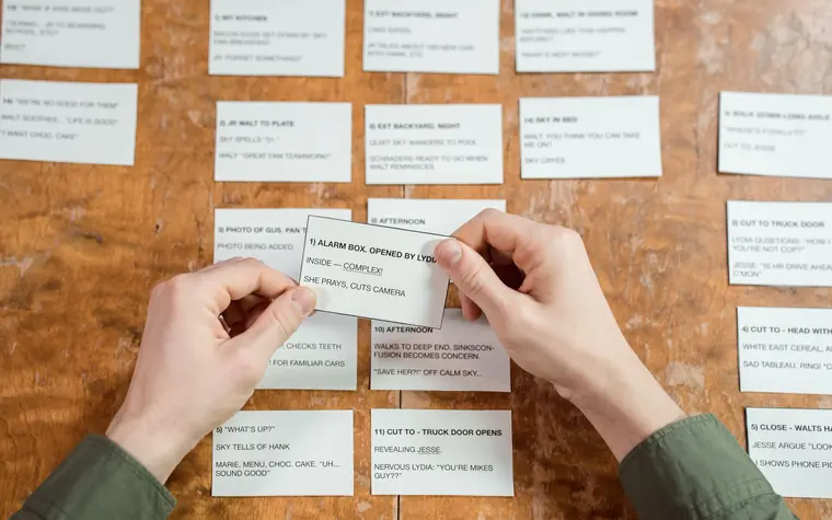 Hands sorting content cards pinned to a board.