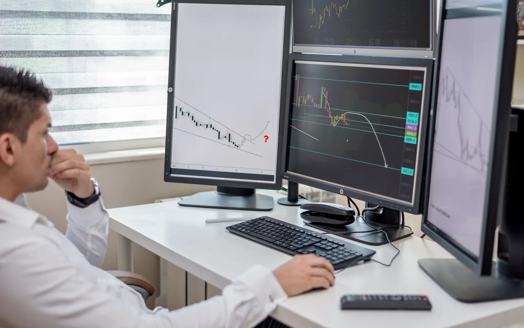 Man using a computer with multiple displays.