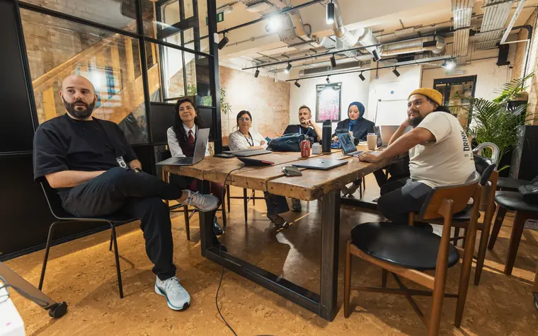 Team meeting around a table in a modern office.