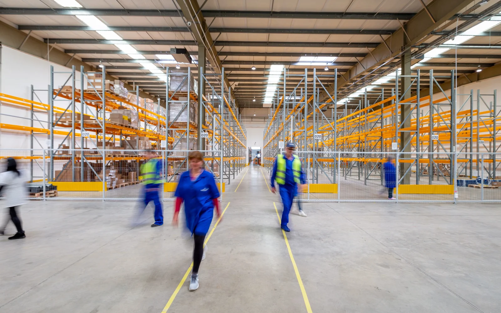 Workers walking through a distribution centre.