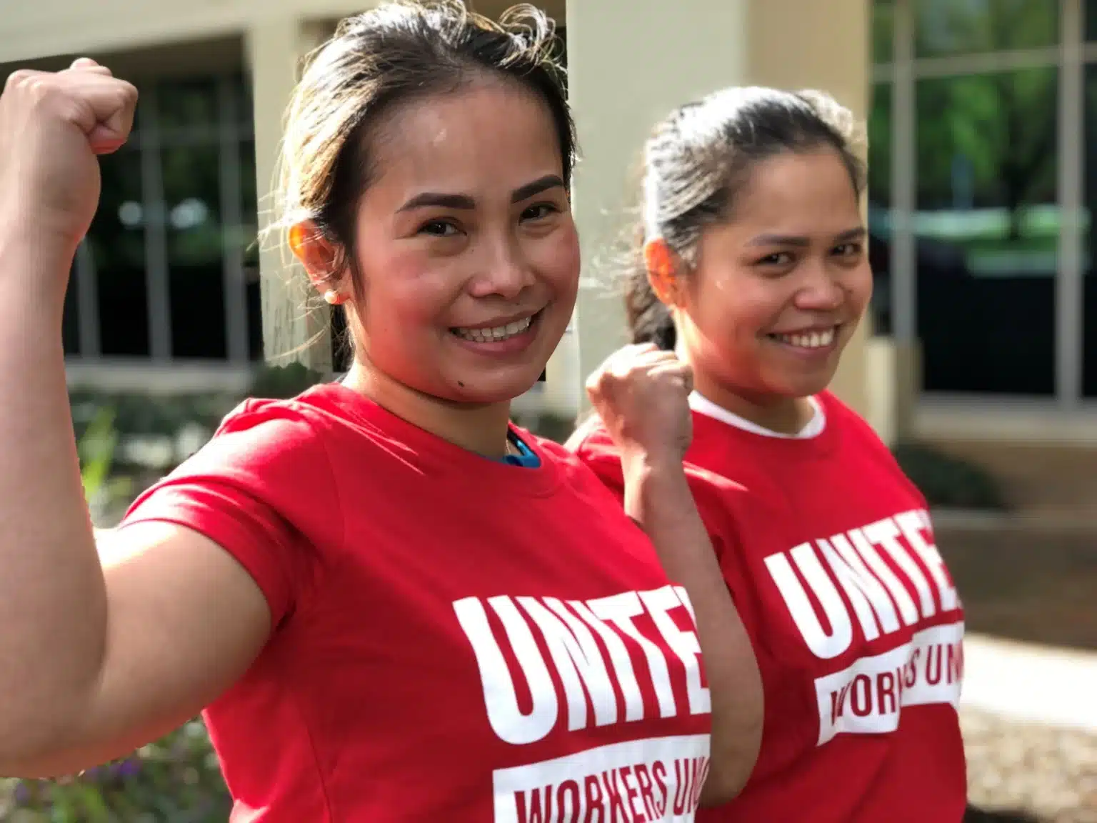 Two United Workers Union members in red shirts.