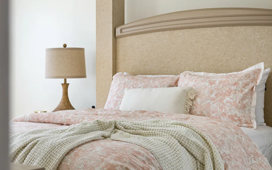Bianca floral quilt cover on a bed with a bedside lamp.