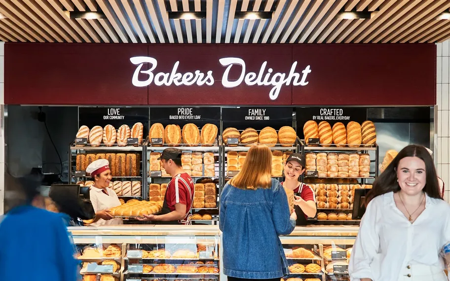 Customers at a Bakers Delight bakery counter.