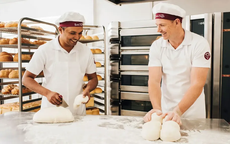 Bakers Delight bakers preparing dough in a working bakery.