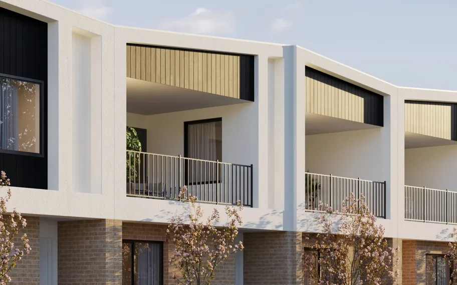 Close-up of Nostra Homes modern townhouse facade with balconies and landscaping.