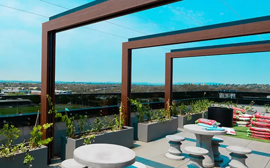 Outdoor seating beneath a timber pergola.