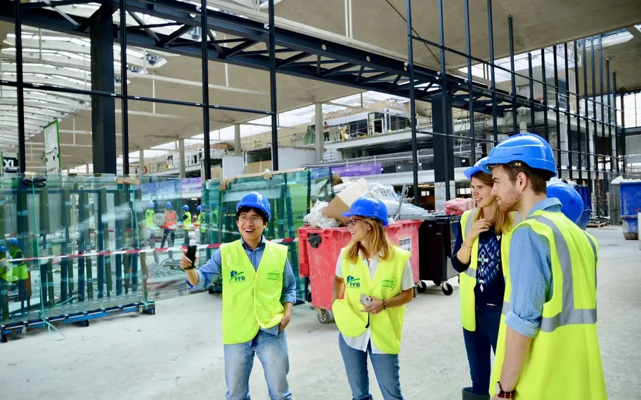 Construction team in hi-vis discussing a project on website.