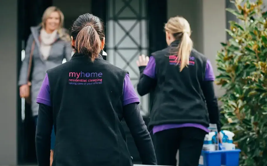 Three people standing outside a house.