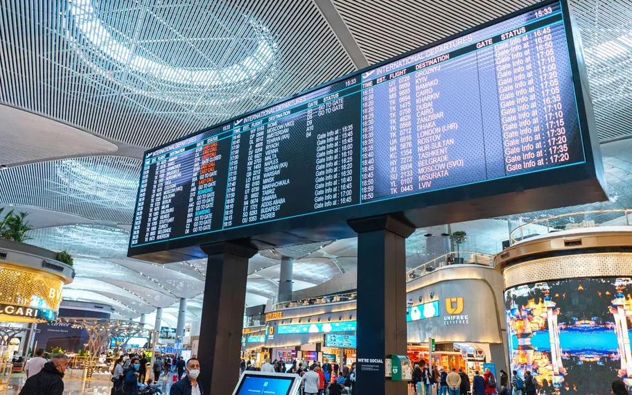 Modern airport duty-free concourse with retail stores.