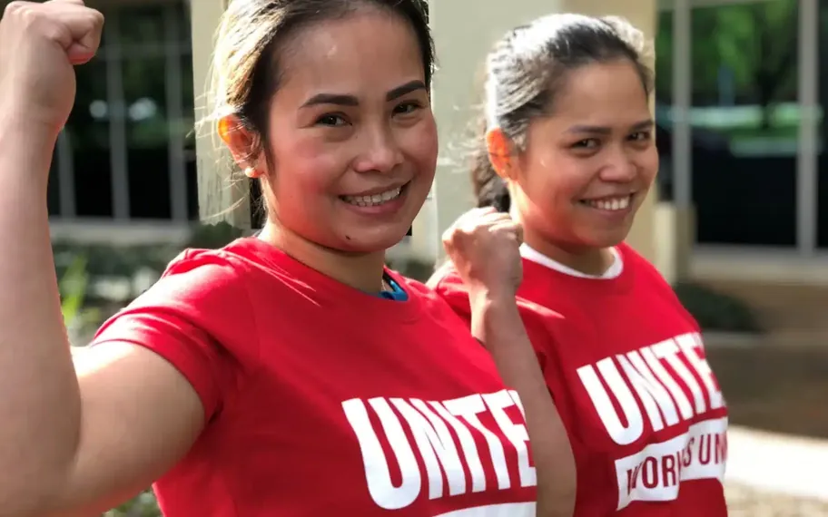 Two United Workers Union members in red shirts.
