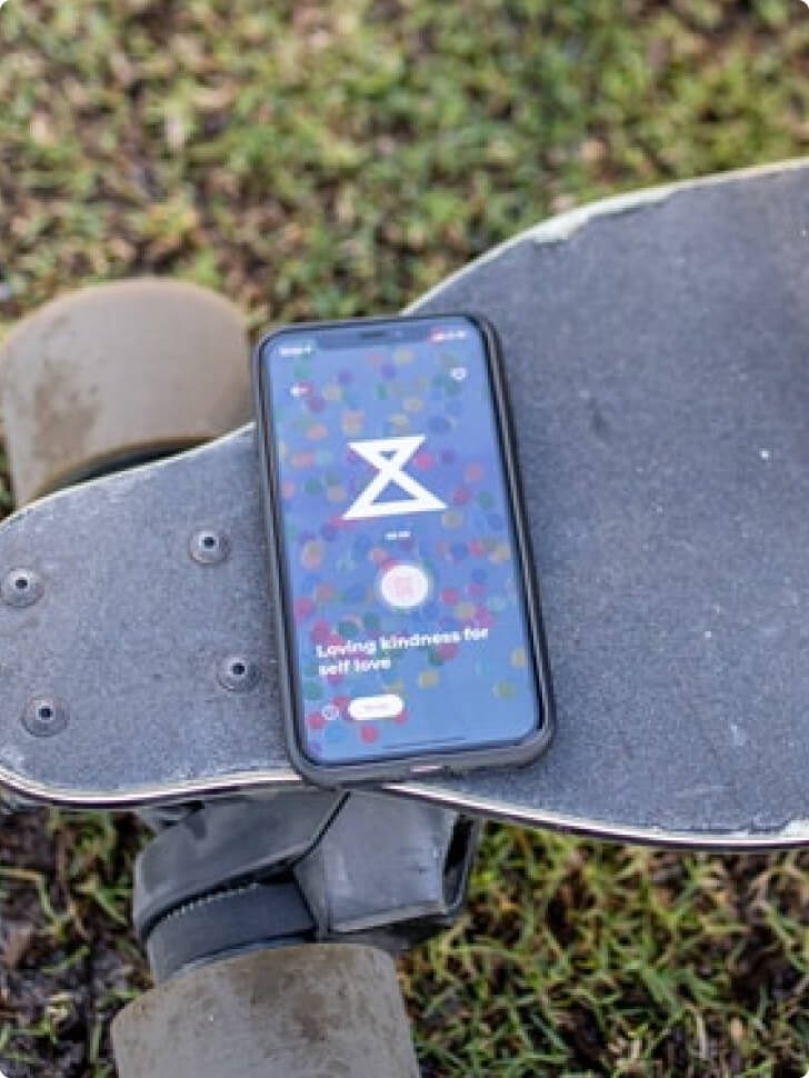 A close-up image of a smartphone suspended above a skateboard